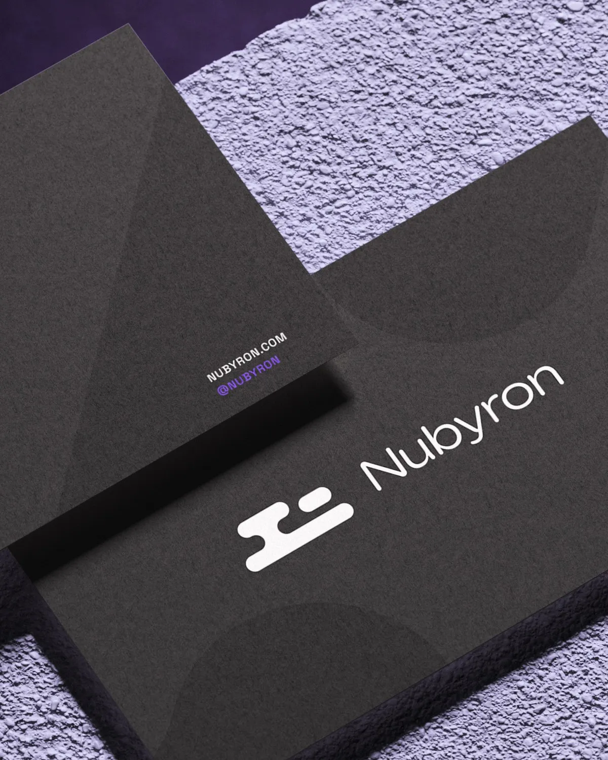 Close-up of a Nubyron business card on a lilac textured surface