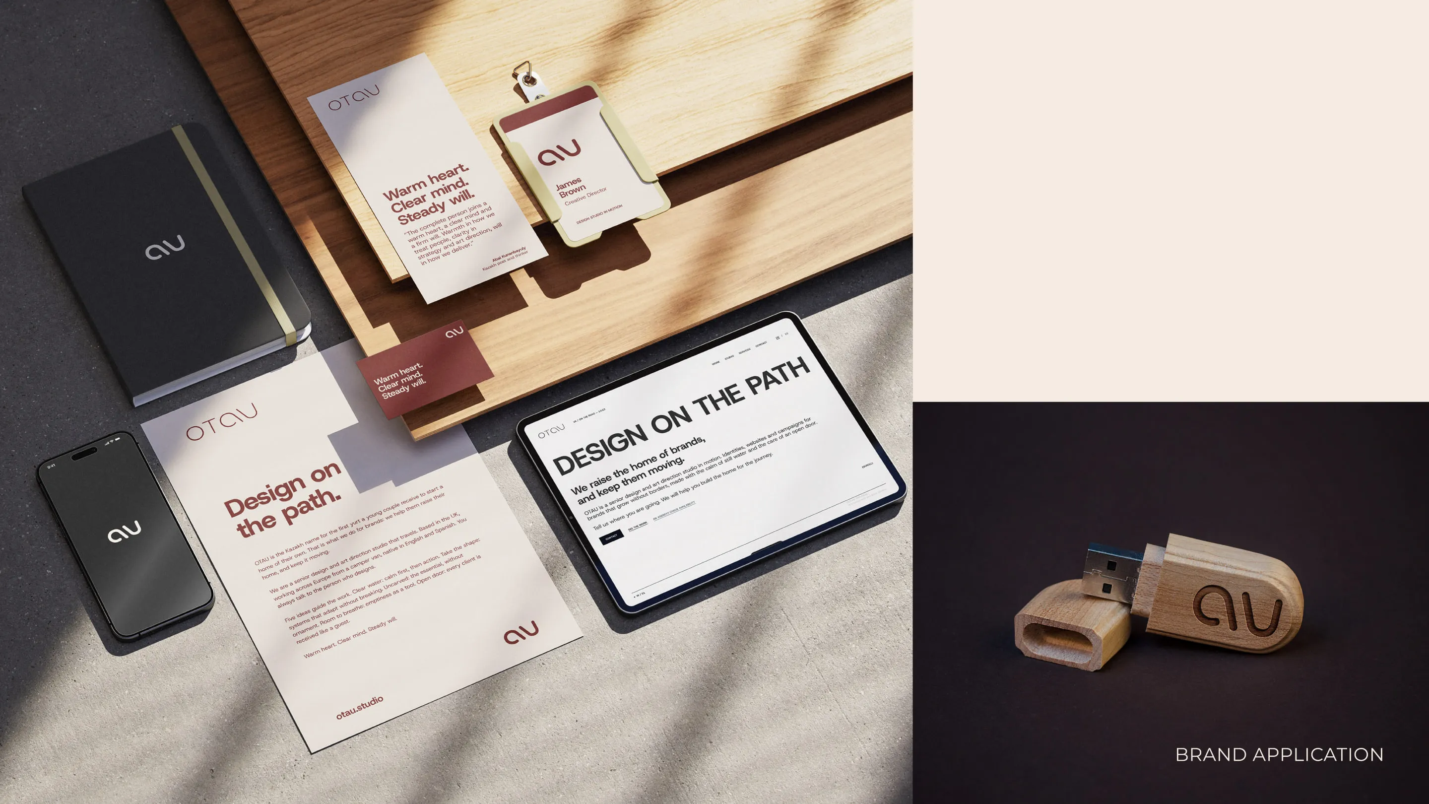 Stationery, phone, tablet and a wooden USB stick with the OTAU isotype